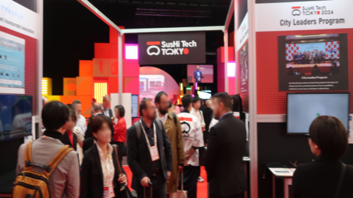 写真:東京パビリオンブース内のSusHi Tech Tokyo 2024 City Leaders Programエリアの様子。紹介映像が放映されるサイネージに多くの来場者が集まっている