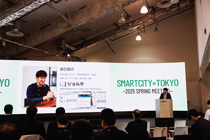 大型ディスプレイの前で発表する株式会社ジョルテ 下花 剛一 様
