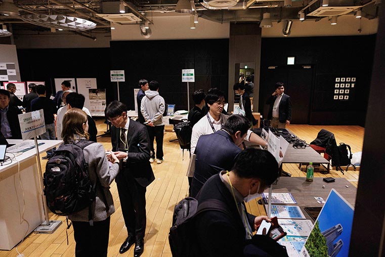 名刺交換を行ったり展示物をみたりしている会場風景